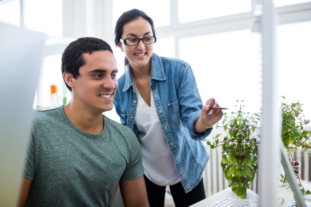 male and female graphic designers interacting over computer